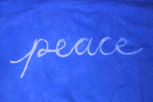 image of blue-dyed shirt with the word peace written in white